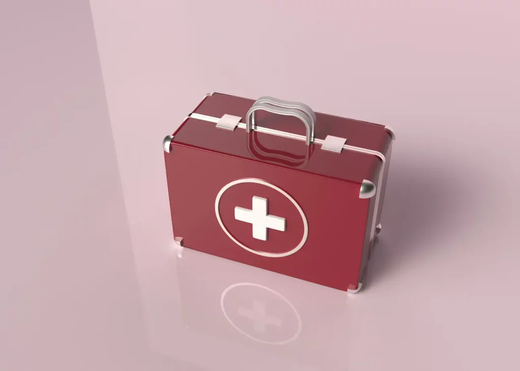 Trousse de premiers soins rouge à croix blanche sur fond rose